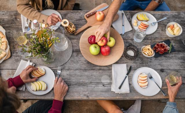 Tavolo da picnic con diverse mele dell'Alto Adige, succo di mela, chips di mela e prodotti locali.