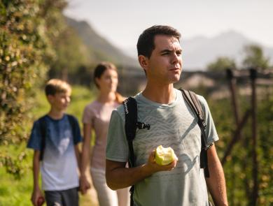 Famiglia in cammino tra i meleti dell'Alto Adige.