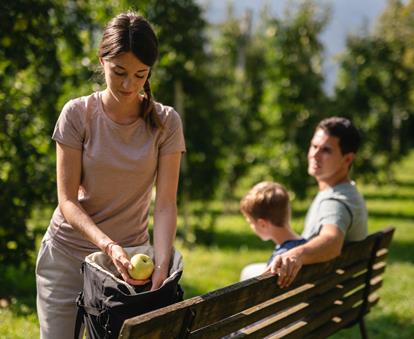 Famiglia porta mele dell'Alto Adige nello zaino durante una passeggiata.